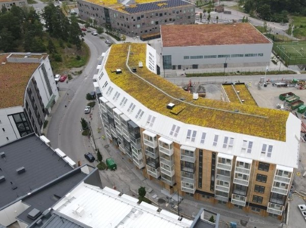 flerbostadshus tagit med dronarfoto, gräs på taket.